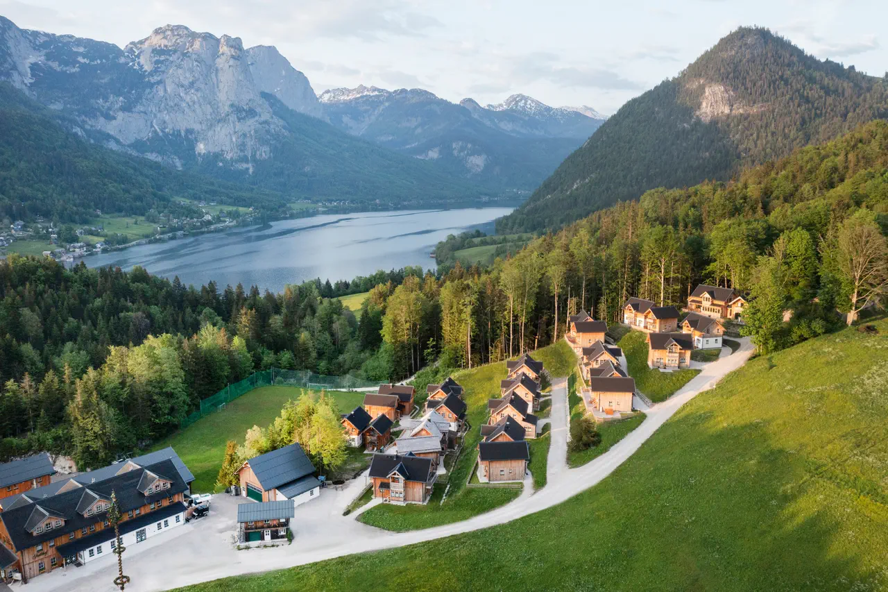 Auf dem Foto haben Sie einen herrlichen Blick auf ein Badesee (im Hintergrund), der von Bergen umgeben ist. Im Vordergrund befindet sich der Eibenwald, vor ihm – das Narzissendorf.